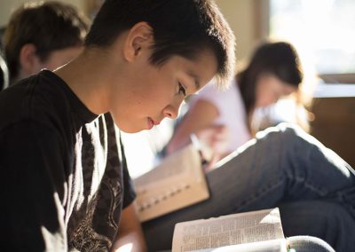 Boy Reading Scriptures in Classroom
